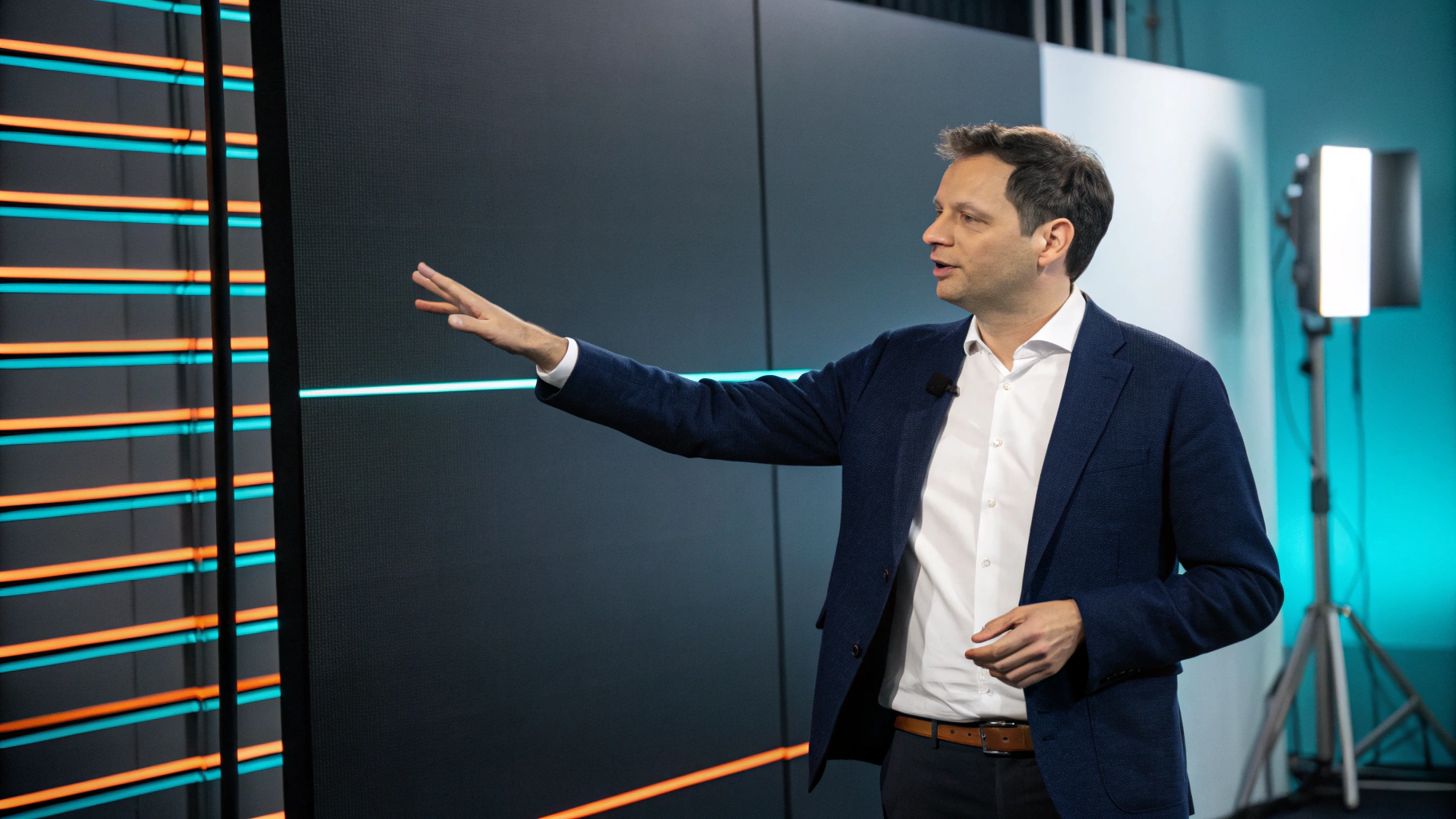 Presenter reviewing car finance cost comparisons on studio display